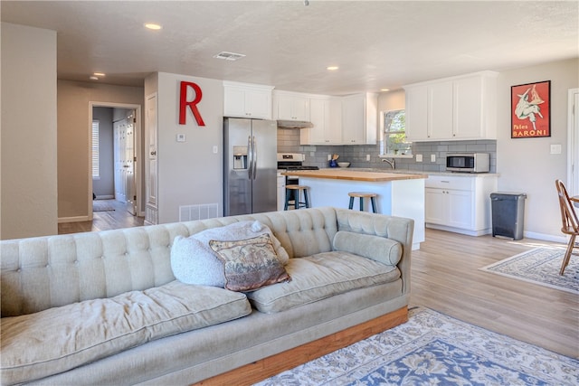 living room with light hardwood / wood-style floors and sink