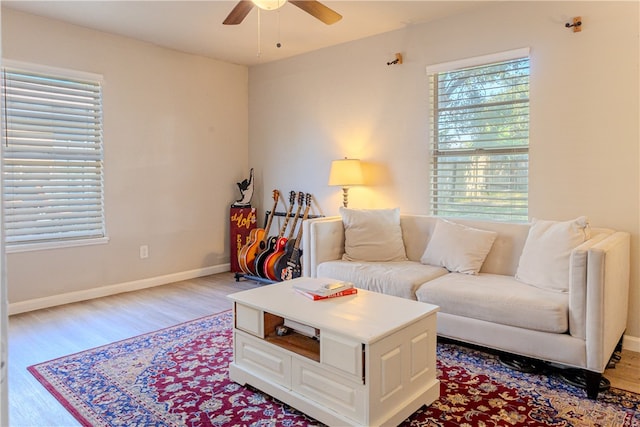 living room with light hardwood / wood-style floors, ceiling fan, and a wealth of natural light