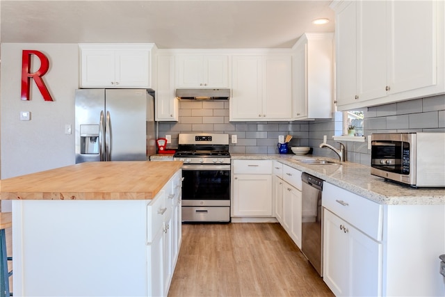 kitchen featuring a kitchen island, appliances with stainless steel finishes, sink, white cabinets, and light hardwood / wood-style flooring