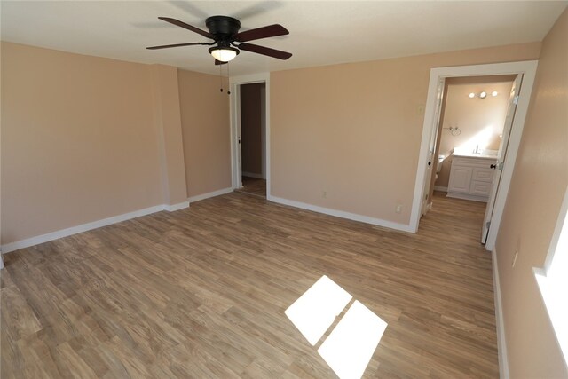 unfurnished bedroom with light hardwood / wood-style floors, ceiling fan, and ensuite bath