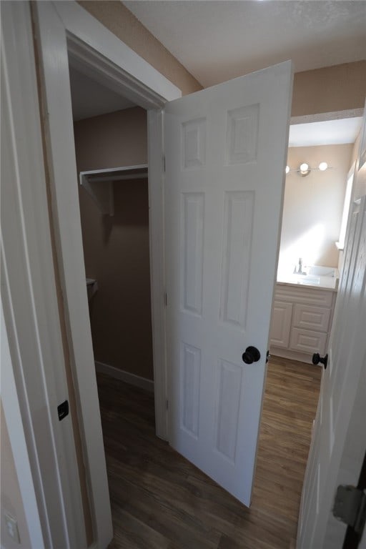 corridor featuring dark wood-type flooring and sink