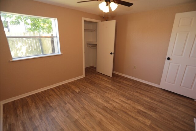 unfurnished bedroom with dark wood-type flooring, ceiling fan, and a closet