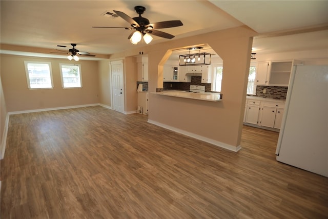 unfurnished living room featuring ceiling fan and wood-type flooring