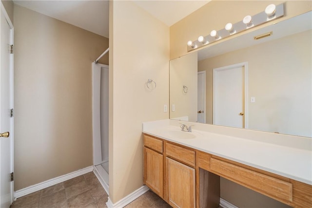 bathroom with baseboards, visible vents, a shower stall, and vanity