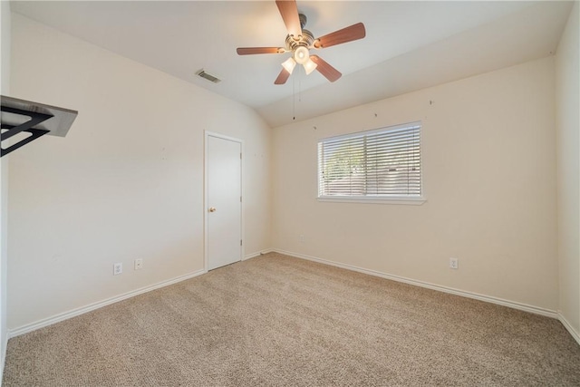 carpeted spare room featuring baseboards, a ceiling fan, lofted ceiling, and visible vents