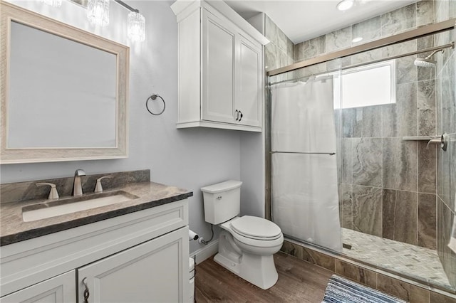 bathroom featuring walk in shower, vanity, wood-type flooring, and toilet