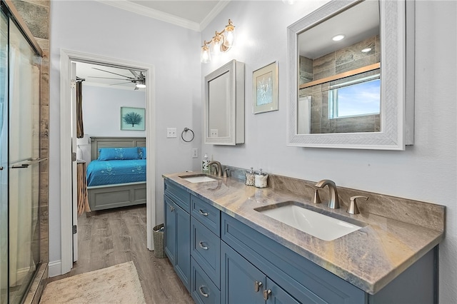 bathroom with hardwood / wood-style floors, a shower with shower door, vanity, and ornamental molding