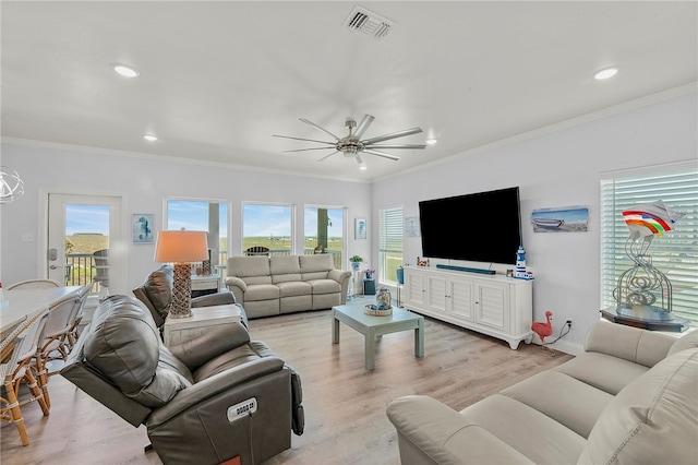 living room featuring ceiling fan, light wood-type flooring, and crown molding