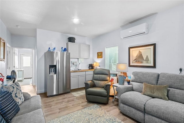 living room featuring a wealth of natural light, a wall unit AC, sink, and light hardwood / wood-style flooring