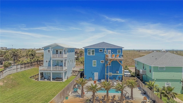 back of property with a lawn and a balcony