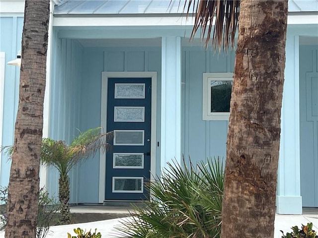 property entrance featuring covered porch and board and batten siding