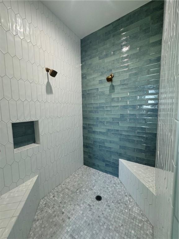 bathroom featuring tile patterned flooring and tiled shower