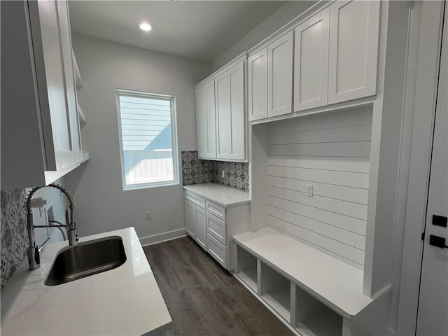 interior space featuring recessed lighting, dark wood-type flooring, baseboards, and a sink