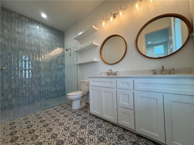 bathroom featuring double vanity, toilet, walk in shower, and a sink