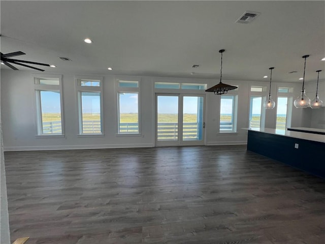 unfurnished living room featuring recessed lighting, visible vents, baseboards, and dark wood-type flooring