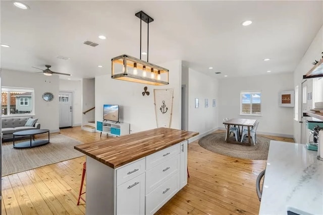 162 La Concha Blvd Unit 20, Port Aransas, TX 78373 - kitchen featuring wooden counters, open floor plan, white cabinetry, light wood-style floors, and a ceiling fan