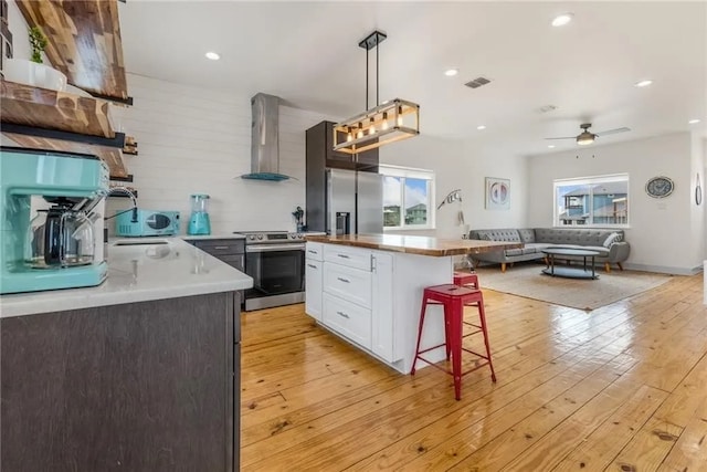 162 La Concha Blvd Unit 20, Port Aransas, TX 78373 - kitchen with appliances with stainless steel finishes, wall chimney range hood, healthy amount of natural light, a kitchen bar, and recessed lighting