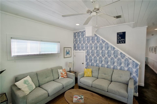 living area with wood ceiling, an accent wall, visible vents, and a ceiling fan