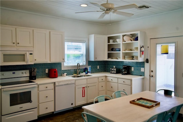 kitchen featuring white appliances, tasteful backsplash, visible vents, white cabinets, and a sink