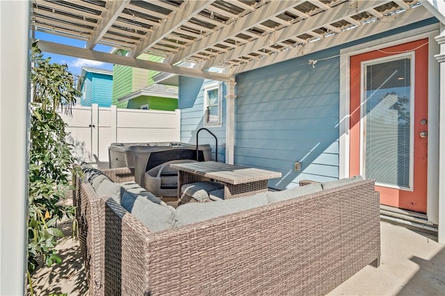 view of patio / terrace with a hot tub, fence, and a pergola