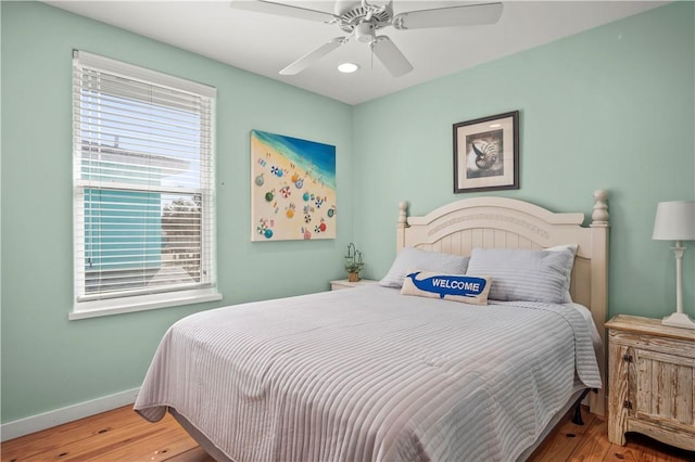 bedroom featuring wood finished floors, a ceiling fan, and baseboards