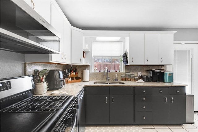 kitchen featuring sink, stainless steel gas range oven, ventilation hood, light tile patterned floors, and white cabinets