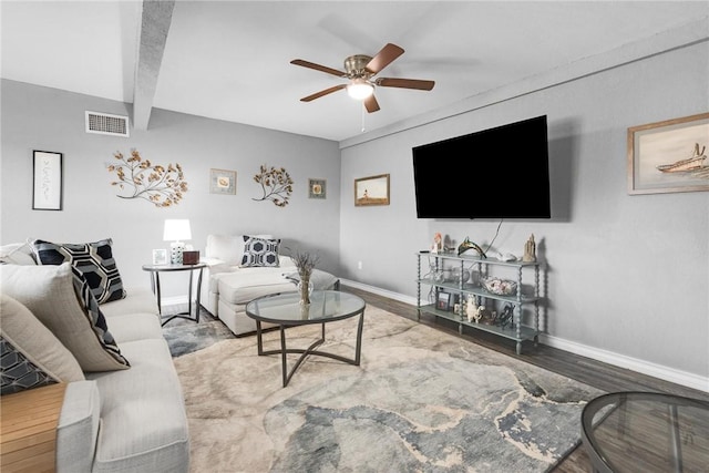 living room featuring beamed ceiling, wood-type flooring, and ceiling fan