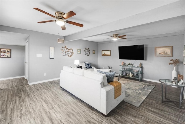 living room featuring wood-type flooring, ceiling fan, and beam ceiling