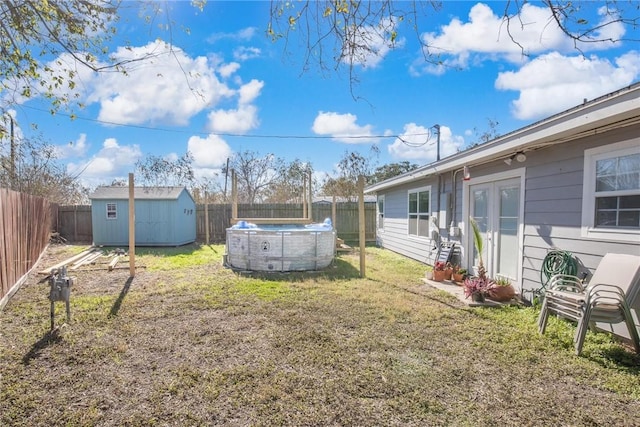 view of yard with a fenced in pool and a storage unit