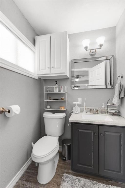 bathroom with wood-type flooring, vanity, and toilet