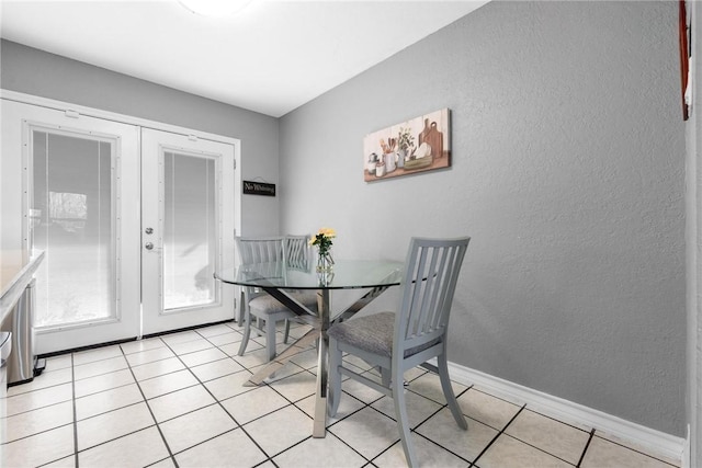 dining area featuring light tile patterned floors and french doors