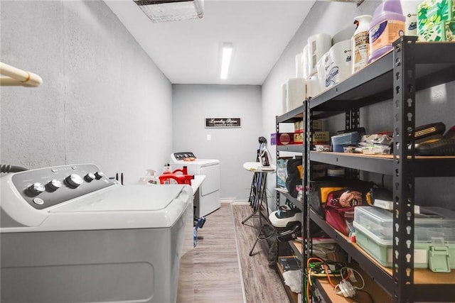 laundry room with independent washer and dryer and light wood-type flooring