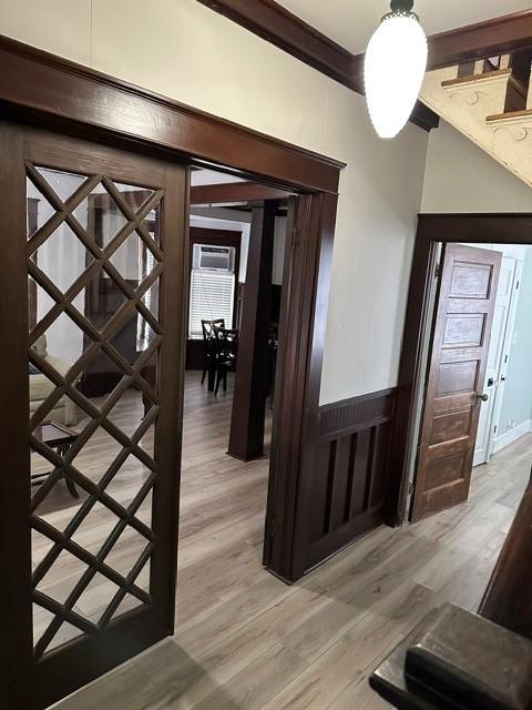 foyer with ornamental molding and light wood-style floors