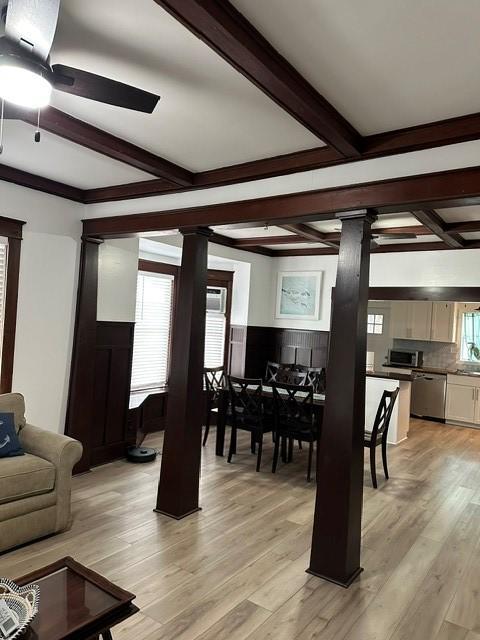 dining area featuring ceiling fan, light wood-type flooring, and decorative columns