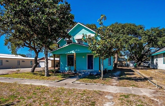 bungalow-style house featuring an outbuilding, a porch, and a garage