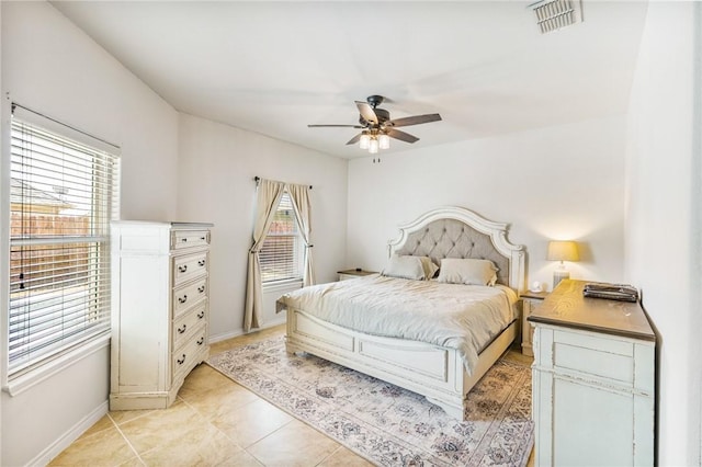 bedroom with a ceiling fan, light tile patterned flooring, visible vents, and baseboards