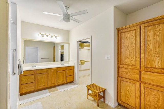 bathroom featuring double vanity, ceiling fan, a spacious closet, and a sink