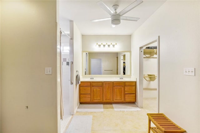 bathroom with double vanity, an enclosed shower, a ceiling fan, and a sink