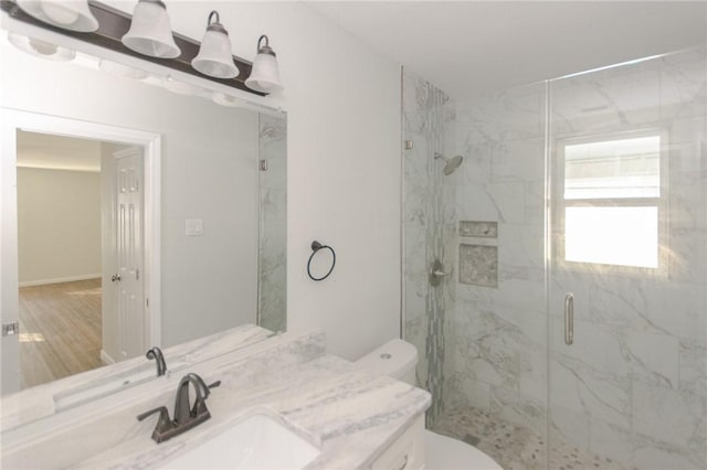 full bathroom featuring a marble finish shower, toilet, and vanity