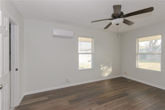 unfurnished room with dark wood finished floors, a healthy amount of sunlight, baseboards, and a wall mounted AC