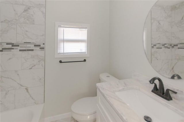 bathroom with baseboards, toilet, and vanity