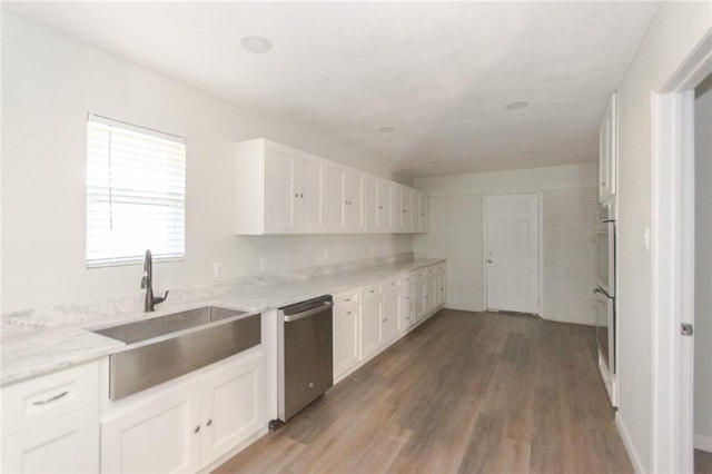 kitchen featuring white cabinets, dishwasher, and a sink