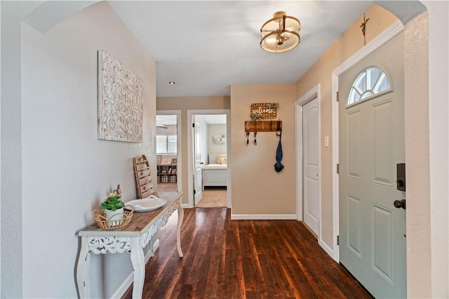 foyer entrance with baseboards and wood finished floors