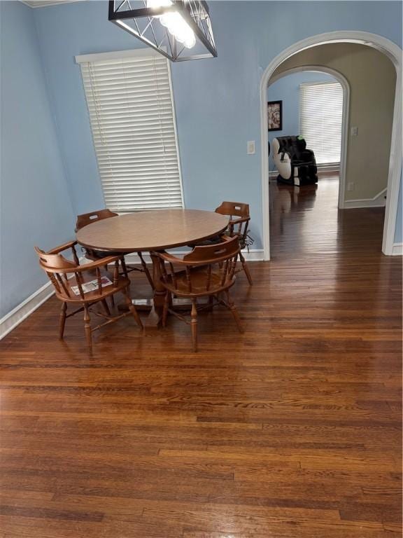 1101 N Adams St N, Beeville, TX 78102 - dining room with arched walkways, dark wood finished floors, and baseboards