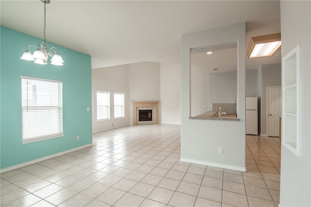 unfurnished living room featuring light tile patterned flooring and a chandelier