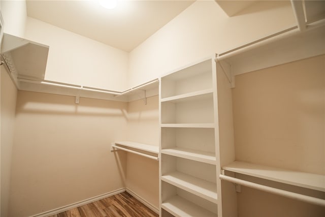 walk in closet with dark hardwood / wood-style floors