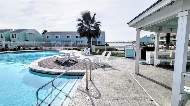 view of pool featuring a patio area and a water view