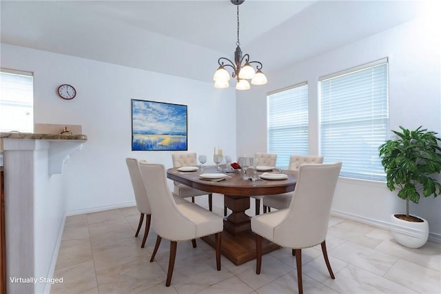 dining room with baseboards and an inviting chandelier