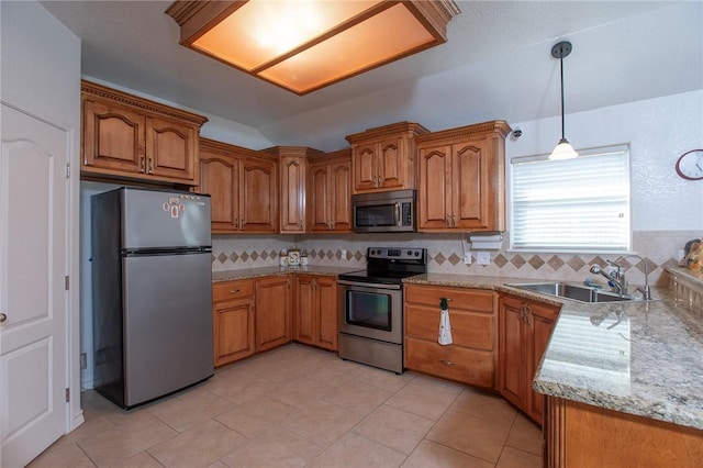 kitchen featuring brown cabinets, pendant lighting, a sink, stainless steel appliances, and decorative backsplash