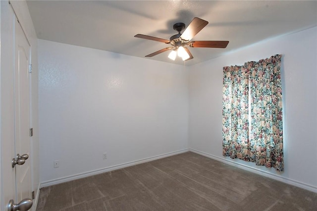 carpeted empty room with baseboards and a ceiling fan